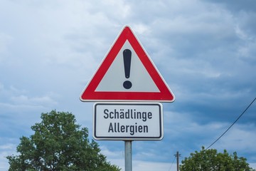 Warnschild vor Schädlingen, die Allergien auslösen können