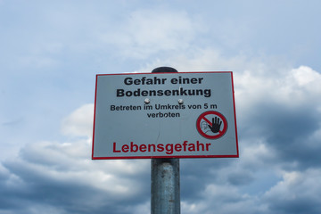 Warnschild vor einer Bodensenkung , weil Lebensgefahr besteht