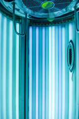 Vertical Tanning turbo Solarium Light Machine with glowing blue light ultraviolet lamps for tanning and skin care. Empty tanning Modern solarium, inside. Horizontal photo