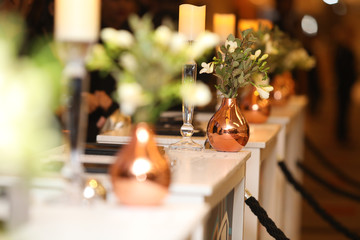Gold vase with pretty white flowers set up for an event.