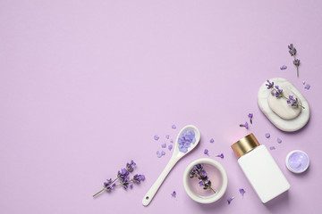 Cosmetic products and lavender flowers on lilac background, flat lay. Space for text
