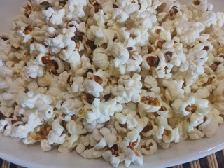 popcorn on white plate close up  food ingredient healthy snack background texture stay home cinema concept