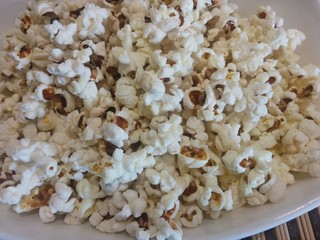 popcorn on white plate close up  food ingredient healthy snack background texture stay home cinema concept