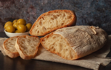 Ciabatta. Fresh italian ciabatta bread with herbs, olive oil and olives, copy space.