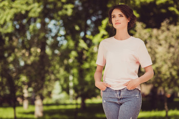 Photo of cute concentrated young girl lady look side watch kids nanny wait friends boyfriend free day walk city park garden green area ecology concept wear beige t-shirt jeans outside