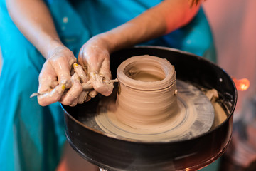 woman potter hands makes on the pottery wheel clay pot, close up. Potter's wheel. Pottery concept. - 372846146