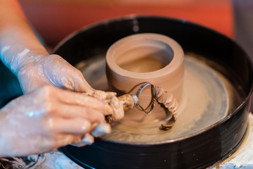 woman potter hands makes on the pottery wheel clay pot, close up. Potter's wheel. Pottery concept. - 372846183