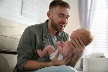 Fototapeta premium Father with his newborn son at home