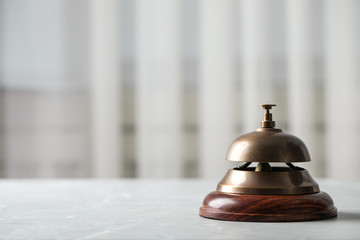 Hotel service bell on table indoors, closeup. Space for text