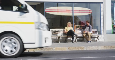 Two Caucasian male surfboard makers sitting on a bench and interacting together - Powered by Adobe