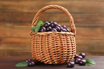 Fototapeta na wymiar Basket and tasty acai berries on wooden table