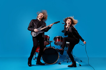Full body photo crazy funky two people popular artist man play bass guitar girl sing composition...