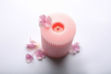 Burning pink wax candle and flowers isolated on white, above view