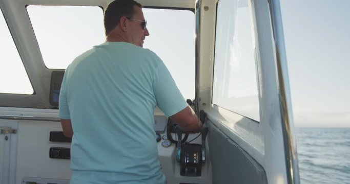 Rear view of a Caucasian man driving a boat