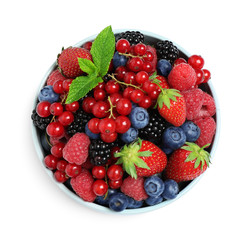 Obraz premium Mix of different fresh berries and mint in bowl on white background, top view