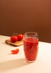 Tomato juice and two tomatoes on the table