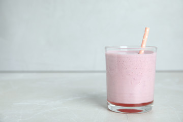 Tasty milk shake with straw on light grey table. Space for text