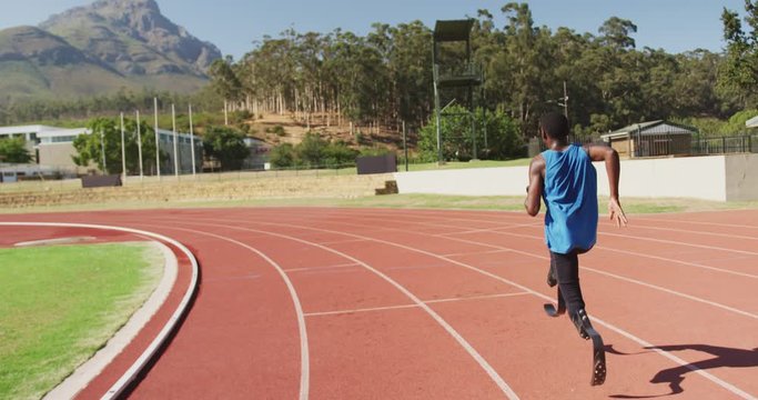 Disabled mixed race man with prosthetic legs running on race track