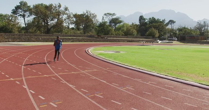 Disabled mixed race man with prosthetic legs running on race track