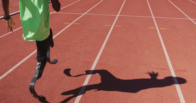Disabled mixed race man with prosthetic legs running on race track