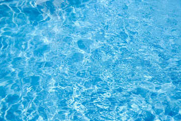 Texture of blue water in swimming pool as background, closeup