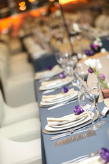 purple flower placed on white plates setup for an event.