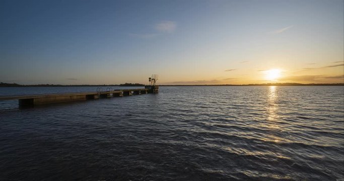 Holy Grail or Day to Night Time Lapse of lake pier during sunset in Ireland.