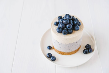 Vegan vanilla blueberry cheesecake against white background.