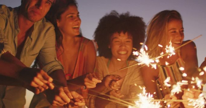 Friends playing with fire on the beach 