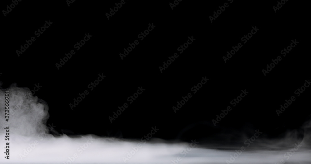 Wall mural low lying fog rolling in over the bottom of the frame against a black background.