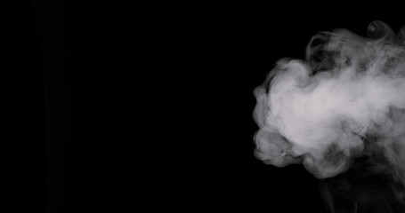 plume of thick smoke flowing in against a black background.