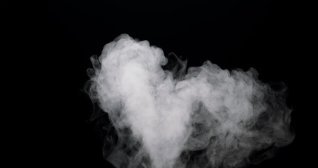 cloud of smoke flowing in over a black background.