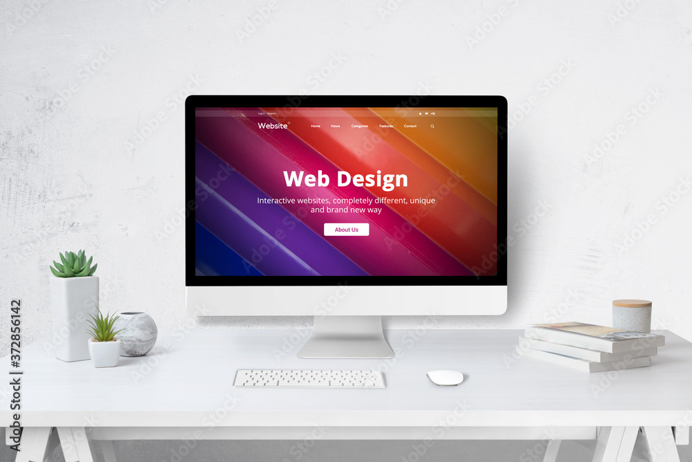 Leinwandbilder Web design studio concept with computer on work desk and company web site on display. White wooden desk with keyboard, mose, plants and books