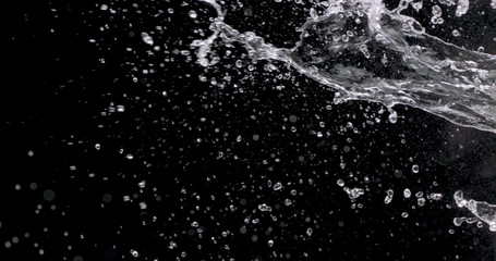 close-up spray of water from the right side of a black background.