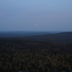 Moonrise over the night forest in the Taganay National Park, South Ural, panorama.