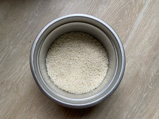 Dry rice in bowl on the floor prepare for cooking. Top view. Close up. Blurred.