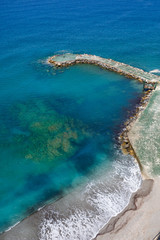 Fototapeta na wymiar Top view of the sea shore with azure water and a sandy beach. Aerial view of the middle earth sea with coastline. Beautiful tropical sea in summer season, shot from drone