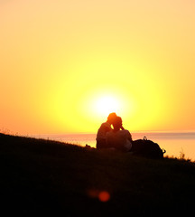 two young people sitting on the background of the sunset. Europe. 14.08.2020