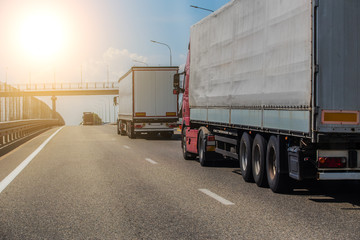 Trucks deliver cargo in opposite directions on a suburban highway