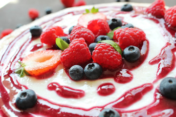 Close up of  berries and coulis on top of cheesecake