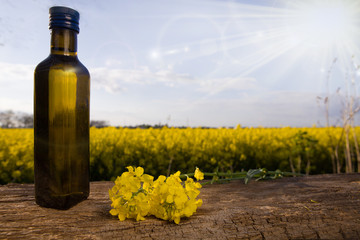 Bottle with oil on a rape field backgroun. Copy speace for text.