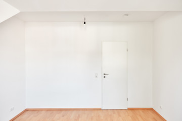 Leerer Raum mit weißen Wänden und geschlossener Tür