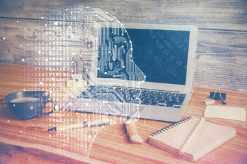Double exposure of work space with computer and human brain drawing hologram. Brainstorm concept.