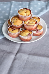 Strawberry muffins on white plate on linen napkin background