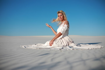 Beautiful bride in the desert on white clean sands
