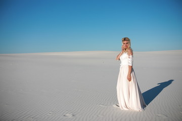 Fototapeta na wymiar Beautiful bride in the desert on white clean sands 