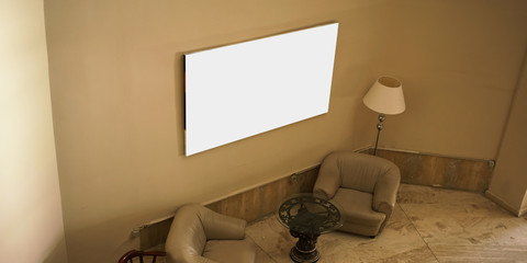 empty white picture hanging on concrete wall in hotel hall interior