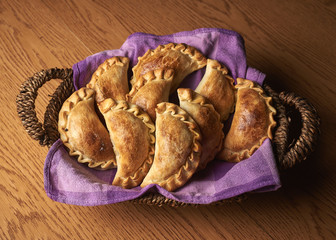 Overhead shot of a basket with freshly baked pastries laid on a purple napkin