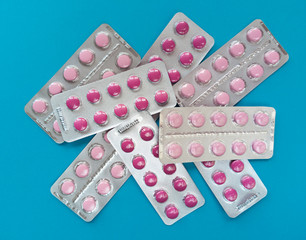 A bunch of pink pills in blisters on blue backgrounds. Medical concept. Stock photo.