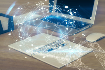 Computer on desktop with social network hologram. Multi exposure. Concept of international people connections.